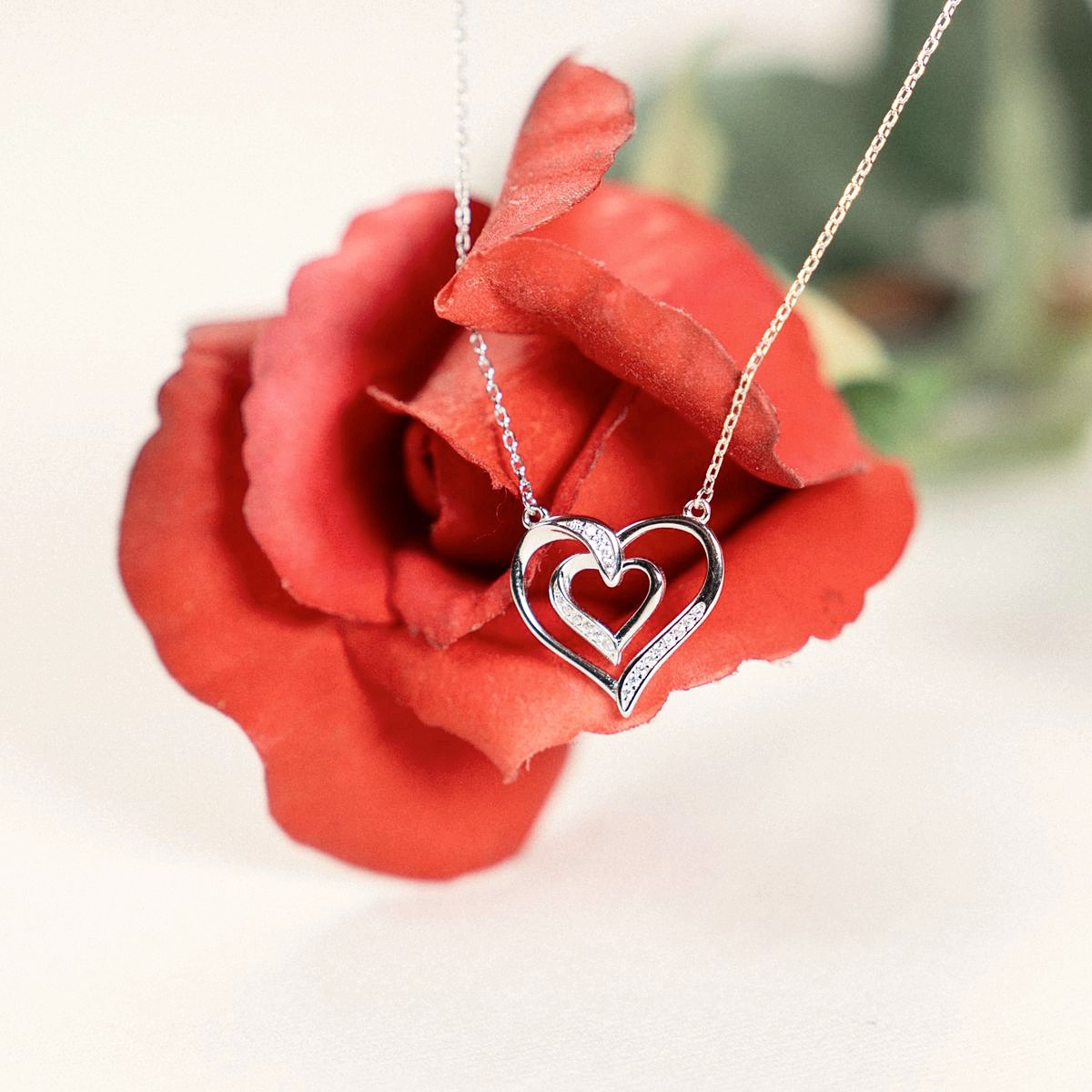 Herzkette auf roter Rose